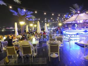 a group of people sitting at tables at a restaurant at night at Lamedina Hotel & Resort in Jounieh