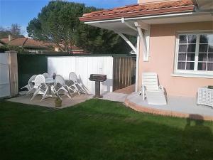 a group of chairs and a grill in a yard at CHEZ MARTINE Appt climatisé 2 Chambres in Capbreton