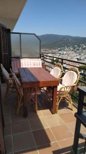 a wooden table and chairs on a balcony at PARADIS TOSSA in Tossa de Mar
