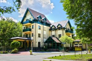 帕利克的住宿－Hotel & Spa PALIĆ RESORT，黑色屋顶的大型黄色建筑