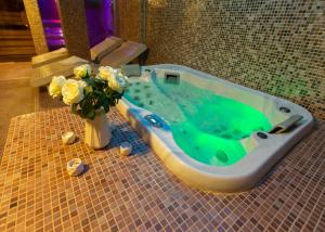 una vasca da bagno con un vaso con fiori di Hotel & Spa PALIĆ RESORT a Palić