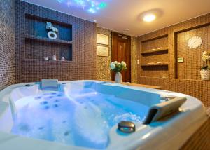 El baño incluye una gran bañera azul. en Hotel & Spa PALIĆ RESORT en Palić