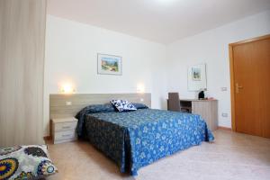 a bedroom with a bed with a blue bedspread at Colibrì in Maierà