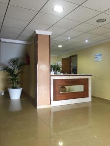 um átrio de escritório com uma recepção e um vaso de plantas em Hotel Rias Baixas em Sanxenxo