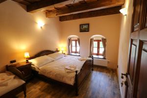 een slaapkamer met een groot bed en 2 ramen bij Villa Marie in Hořice na Šumavě