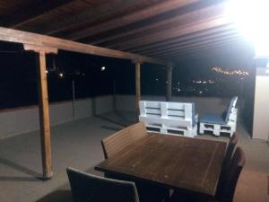 a table and chairs on a balcony at night at Mirina View Apartment in Myrina +6 photos
