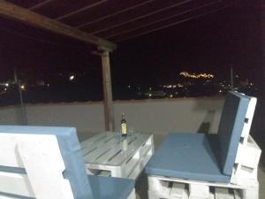 a bottle of wine on a table and chairs on a roof at Mirina View Apartment in Myrina