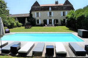 a large swimming pool in front of a house at Moon River Grande Maison in Saint-Cyprien