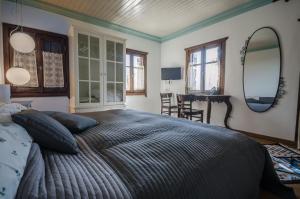 1 dormitorio con 1 cama grande y 2 espejos en Riga's Pinakoti Lodge, en Pinakátai