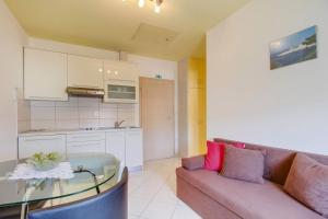 a living room with a couch and a glass table at Apartment Jasna Near Čikat Bay and Center with Private Parking in Mali Lošinj