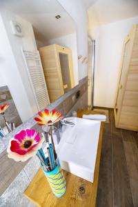 a bathroom with a sink and a vase with flowers at Fenat in Introd +19 photos