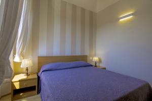 a bedroom with a purple bed and two night stands at CASA BICE in Rio nellʼElba