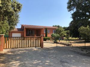 a house with a wooden gate and a fence at La Maison Bougnette in Flassan