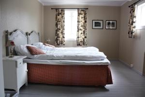 a bedroom with a large bed with white sheets at Rundhaug Gjestegard in Rundhaug +33 photos