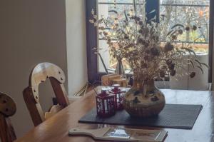 een houten tafel met een vaas met bloemen erop bij Riga's Pinakoti Lodge in Pinakátai