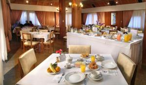 una sala da pranzo con tavolo e cibo di Hotel Edelweiss a Villa General Belgrano
