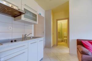 a kitchen with white cabinets and a sink and a bathroom at Apartment Jasna Near Čikat Bay and Center with Private Parking in Mali Lošinj +27 photos