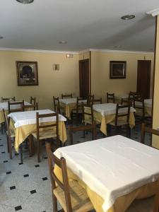 a dining room with tables and chairs with white tables at Hotel Rias Baixas in Sanxenxo