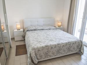 sypialnia z dużym łóżkiem i 2 lampkami na stołach w obiekcie Appartamento Mare e Relax a Castelsardo w mieście Castelsardo
