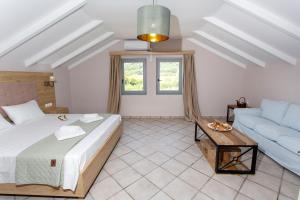 una camera da letto con un letto e un divano di Caretta - Caretta Hotel a Ligia