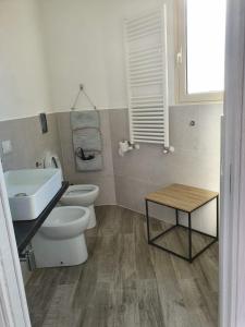 a bathroom with a sink and a toilet and a table at Casa del Moro in Cefalù