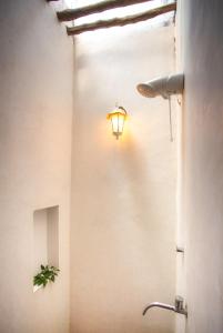 een badkamer met een licht op de muur en een wastafel bij Pousada Jangada Prea in Prea