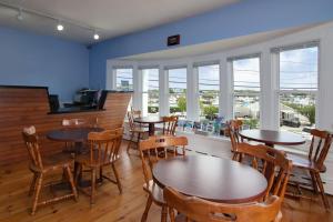 een eetkamer met tafels, stoelen en ramen bij Cape Cod Harbor House Inn in Hyannis