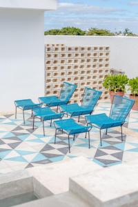 eine Gruppe blauer Stühle auf einer gefliesten Terrasse in der Unterkunft Studios Downtown Cancun in Cancún