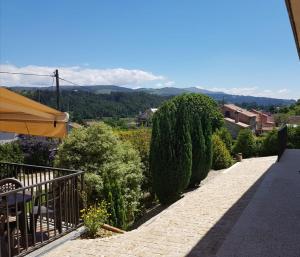 a walkway with bushes and an umbrella on a building at O Refuxio de la Jerezana in Redondela