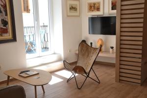 a living room with a chair and a table and a tv at Apartmani Art Karampana in Kotor