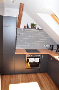 cocina con armarios grises y horno con fogones en Hygge, en Clenze 4 fotos más