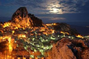Una ciudad iluminada por la noche con una montaña en Casa Mulè, en Caltabellotta