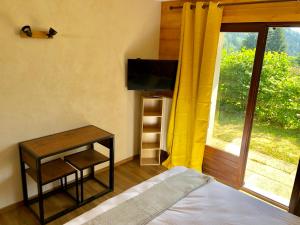 a bedroom with a bed and a table and a window at Residence le Dahu in Saint-Jean-de-Sixt