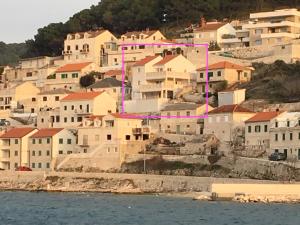 a group of houses on a hill next to the water at Villa More in Pučišća