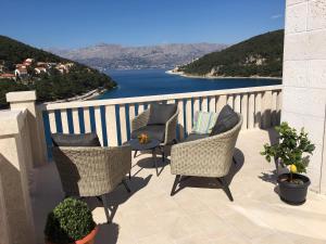 a balcony with chairs and a table with a view of the water at Villa More in Pučišća