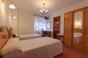 Habitación de hotel con 2 camas y espejo en Casa Cazoleiro en Meira