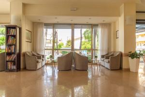a living room with chairs and a large window at Hotel Ascot in Cervia