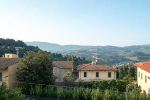 uma vista para uma aldeia com montanhas ao fundo em Casa Torrini em Fiesole