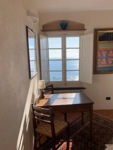 einen Tisch und Stühle in einem Zimmer mit Fenster in der Unterkunft Villa CieloMare in Camogli