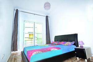 a bedroom with a bed with a large window at Appart Clim Wifi 700m de la Plage in Saïdia