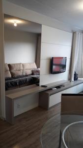 a living room with a couch and a flat screen tv at Apto prox. BR470 in Bento Gonçalves