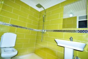 a yellow tiled bathroom with a sink and a toilet at Appart Clim Wifi 700m de la Plage in Saïdia