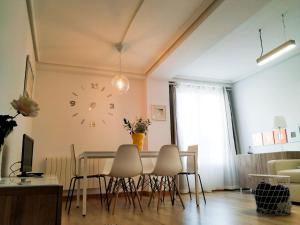 a dining room with a table and chairs and a clock on the wall at Living Burgos in Burgos