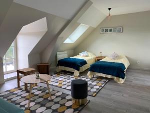 a attic room with two beds and a table at La maison des Légendes in Paimpont