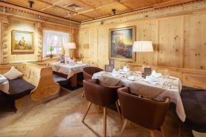 a restaurant with wooden walls and tables and chairs at Hotel Goldener Adler in Ischgl