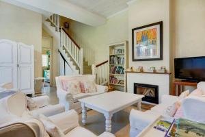 a living room with white furniture and a fireplace at Villa Garda B&B in Cape Town