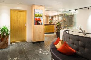 a lobby with a couch and a wooden door at Hotel Goldener Adler in Ischgl