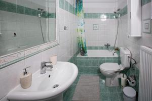 a bathroom with a sink and a toilet and a tub at Antigone Apartments Argostoli (Spilia) 4 in Argostoli +36 photos