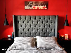 sypialnia z łóżkiem z czerwoną ścianą w obiekcie Casa Blanca Boutique & Organic w mieście Cancún