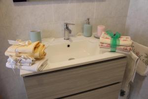 un lavandino in bagno con asciugamani e candele di La casa di Nonna Clo, nel centro di Vasto a Vasto